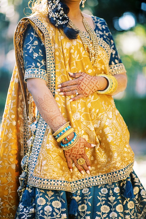 Woman in traditional attire with henna designs.